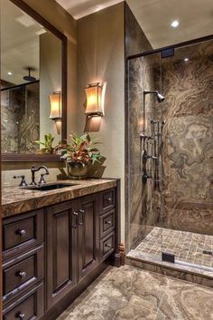 a bathroom with a walk in shower next to a double sink vanity and large mirror