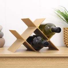 two bottles of wine sitting on top of a wooden shelf next to a potted plant