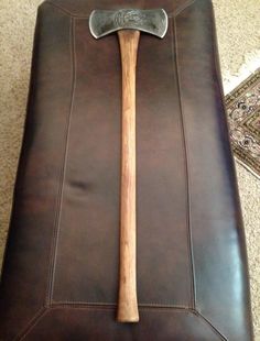 a large wooden mallet sitting on top of a brown leather ottoman