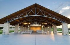 an outdoor pavilion with benches and lights