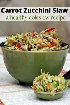 carrot zucchini slaw in a green bowl with a spoon next to it