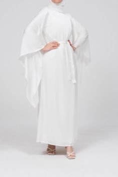 The Eternal Ivory Satin Kimono Sleeve Nikah Maxi Dress is designed for those cherished moments of love and celebration. Crafted from luxurious satin, this dress features a timeless, clean-cut front and gracefully draped extra-long kimono sleeves, offering both elegance and modesty. The detachable belt cinches the waist, creating a flattering silhouette, while the dress's comfortable lining ensures ease of wear. Perfect for special occasions like Nikah or bridal events, this sophisticated maxi dr Elegant White Satin Maxi Dress, White Flowy Gown For Party, Elegant White Satin Dress For Formal Occasions, White Flowy Party Gown, White Satin Floor-length Dress, Wedding Maxi Dress With Satin Finish, White Satin Maxi Dress For Formal Occasions, Elegant Satin Finish Maxi Dress For Wedding Night, Elegant Satin Maxi Dress For Wedding