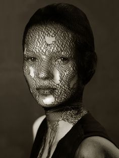 a woman with white makeup and veil on her face