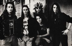 an old black and white photo of five young men standing in front of a brick building