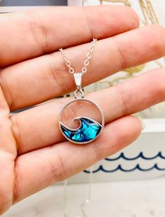 "This beautiful Blue Paua Abalone Ocean Wave necklace is perfect for any occasion!  Love that feeling of peace that the Ocean always seems to bring? Imagine taking the beach with you everywhere you go! This gorgeous handmade resin necklace makes the perfect jewelry choice for a beach vacation, a gift for a best friend, or just a reminder of the sea.  Necklace is handmade with blue paua abalone, resin and your choice of either silver plated or sterling silver necklace chain.  Paua abalone is a natural shell that is beautifully colorful and has opalescent blues and greens. The colors are rich and radiant. Paua is a unique species of abalone found only in New Zealand's environmentally pure coastal waters. Pendant measurements: 2.3 cm long and 2 cm wide Necklace Length: 18 or 20 inches long  C Wave Pendant, Tropical Gifts, Sea Necklace, Silver Necklace Chain, Resin Jewelry Diy, Wave Necklace, A Best Friend, Minimalist Gifts, Sterling Silver Chain Necklace