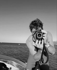 a man taking a photo on a boat in the ocean with his camera attached to it