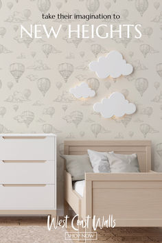 a baby's room with balloons and clouds on the wall