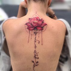 the back of a woman's neck with a lotus tattoo on it