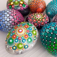 colorful painted eggs sitting on top of a white table