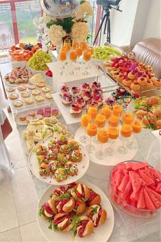 a table filled with lots of food and drinks on top of white plates next to each other