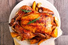 a roasted chicken and french fries on a white plate