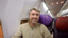 a man is sitting on an airplane with his feet propped up in front of him