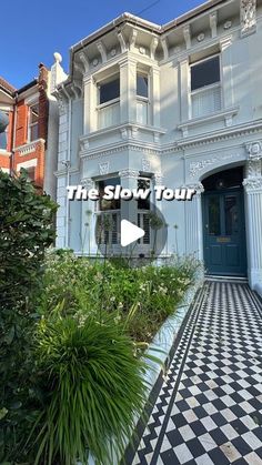 the slow tour video is displayed in front of a white building with black and white checkered flooring