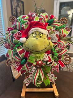 a christmas wreath with the grin face on it, sitting on top of a wooden table