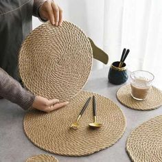 a person is making placemats out of jute and gold metal spoons