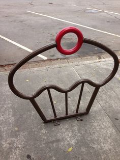 a red ring on top of a brown metal fence next to a parking lot with white lines