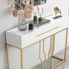 a white console table with gold accents and flowers