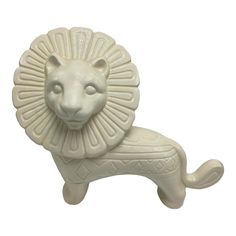 a white lion figurine sitting on top of a table