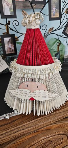 an origami lamp made out of book pages with a red shade on top