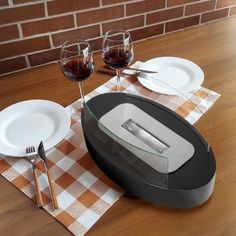 a table with plates, glasses and utensils on it next to a toaster