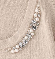 a close up of a necklace with pearls on it's neck and beads attached to the back