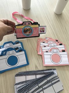 a person holding a camera next to some cards