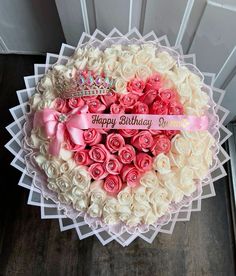 a heart shaped box filled with pink and white roses