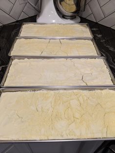 three pans filled with food sitting on top of a counter