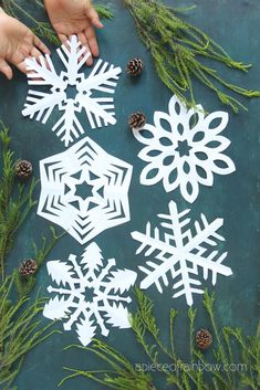 paper snowflakes and pine cones on a table