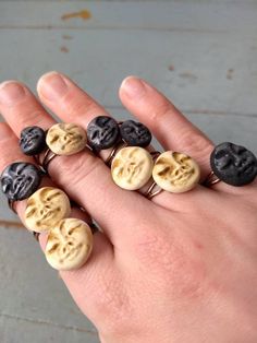 a person's hand with five buttons in the shape of skulls on them,