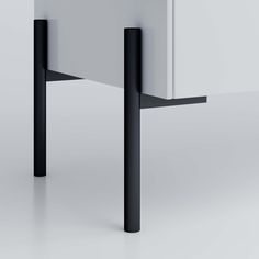 a white and black table with two legs on the top, one leg is bent over