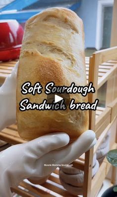 a person holding a loaf of bread in their hand with the words soft sourdough sandwich bread