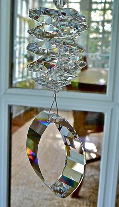 a crystal chandelier hanging from a window sill in front of a glass door