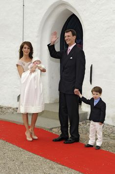 a man, woman and child are waving at the camera