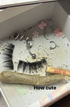 there is a fake eyelashes in a box with some other items on the table next to it