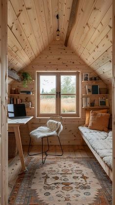 a room with wooden walls and flooring has a bed, desk, chair, rug and window