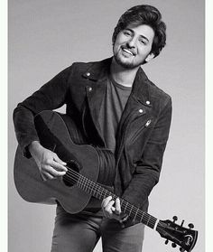 a black and white photo of a man holding a guitar