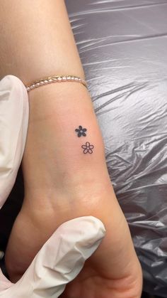 a small four leaf clover tattoo on the left side of the foot, which is attached to a white glove