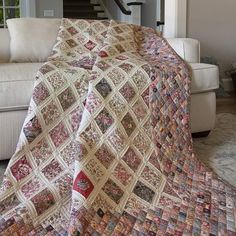 a living room with a couch and a quilted blanket on top of the floor