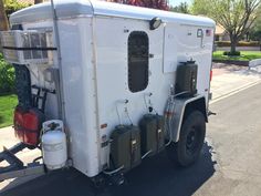 a white trailer parked on the side of a road next to a red fire hydrant