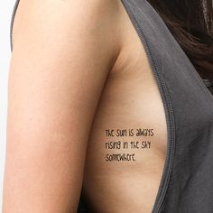 the back of a woman's shoulder with an inscription on it that reads, the sun is always rising in the sky somewhere