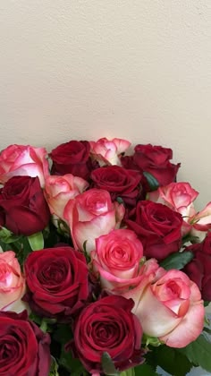 a vase filled with red and pink roses