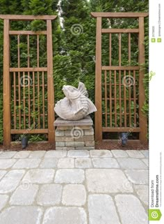 a stone statue sitting in front of a wooden gate