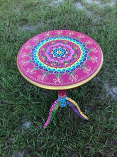 a colorful table sitting on top of a lush green field