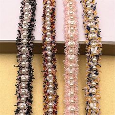 several different types of pearls are hanging on the wall next to each other in an assortment of colors