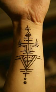 a person's wrist with a tattoo on it that has an image of a cross in the middle