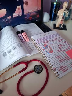 an open book with a stethoscope on top of it next to a laptop