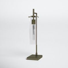 a tall glass and metal stand with a clock on it's side, against a white background