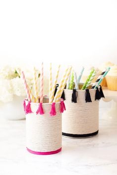 some straws are in small containers with tassels