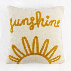 an embroidered pillow with the word sunshine on it's front and back, sitting on a white surface